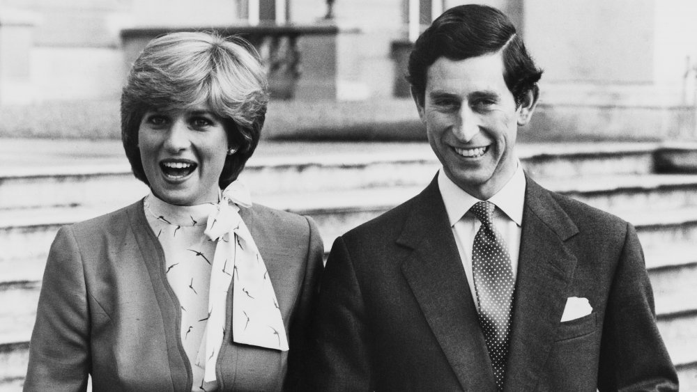 Black-and-white photo of Princess Diana and Prince Charles arm in arm and smiling
