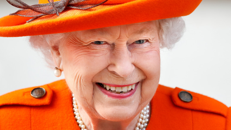 smiling Queen Elizabeth II dressed in orange