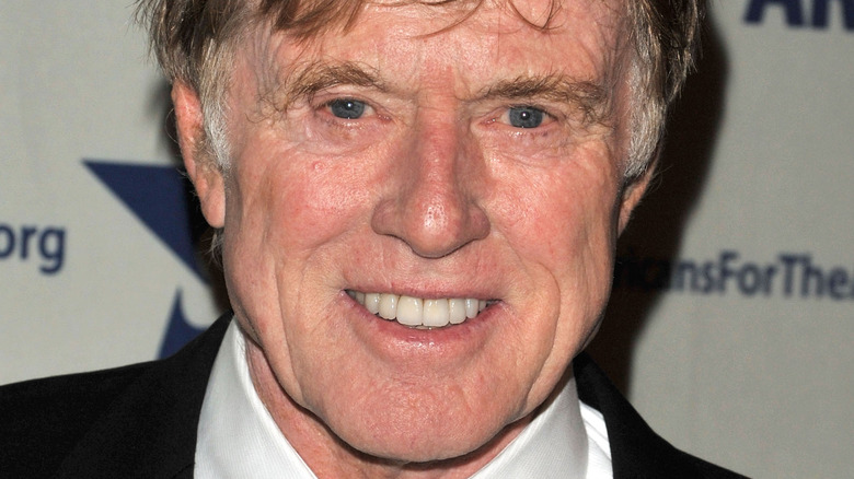 Robert Redford smiles is a dark suit.