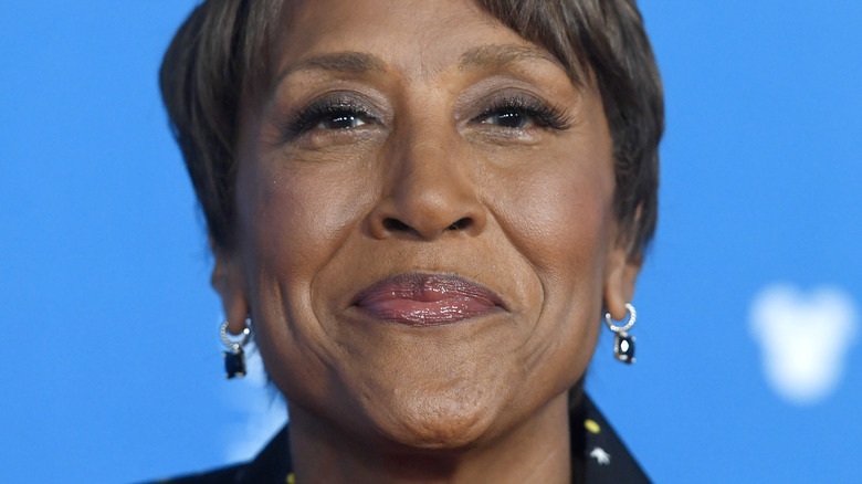 Robin Roberts smiles in front of blue backdrop
