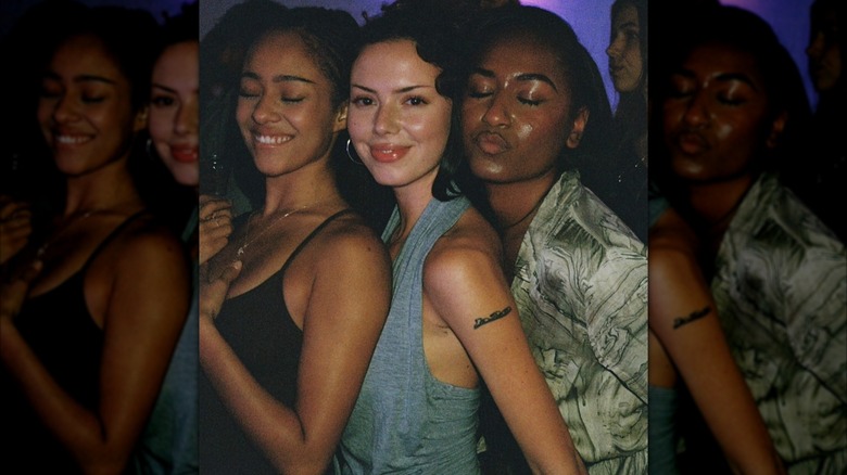 Sasha Obama leans toward friends and puckers her lip with her eyes closed.