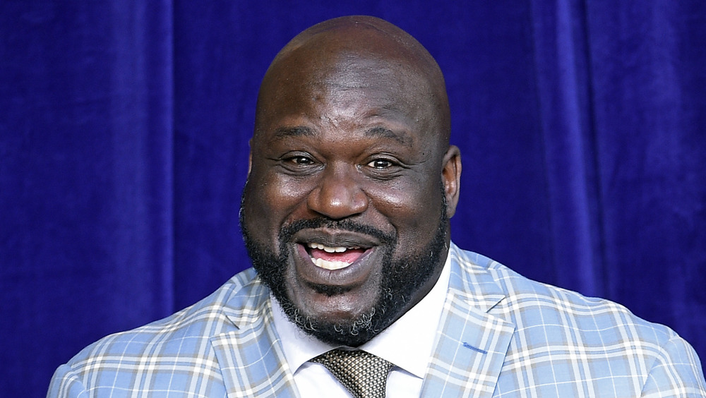 Shaquille O'Neal smiling in light blue plaid blazer