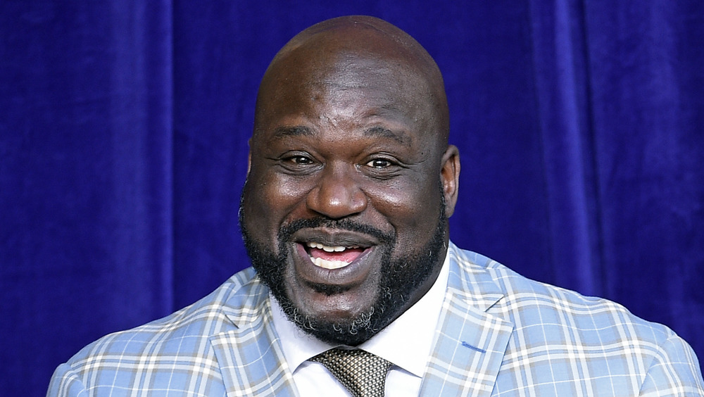 Shaquille O'Neal smiling in light blue plaid blazer