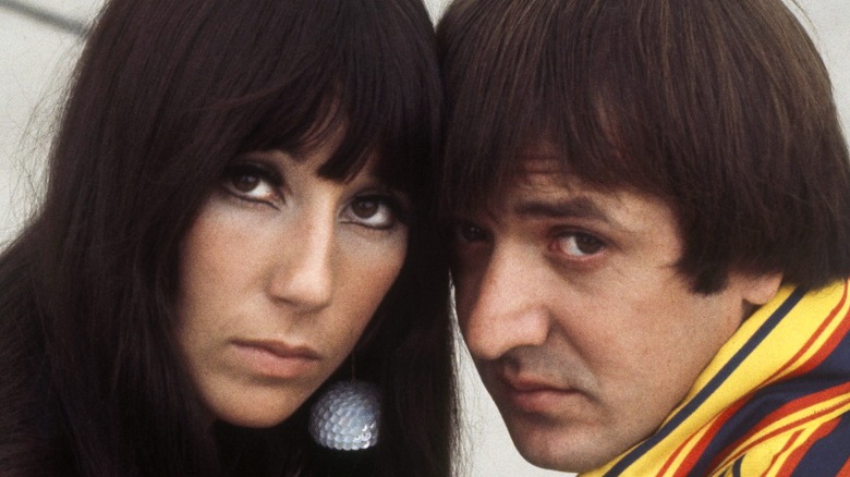 Sonny and Cher resting their heads against one another