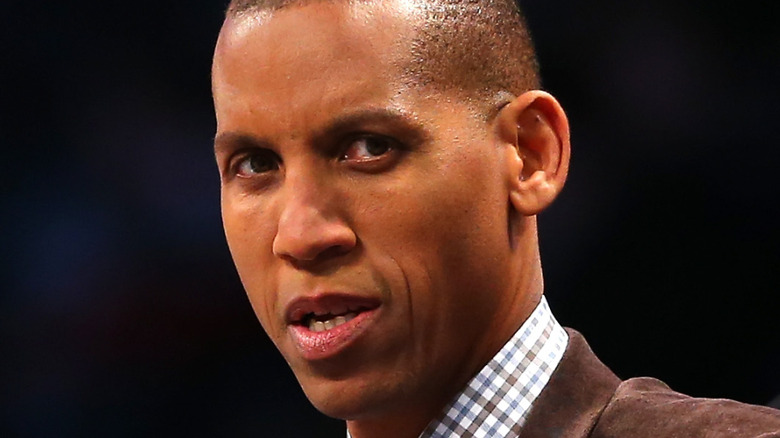 Reggie Miller wearing a brown blazer and checkered shirt