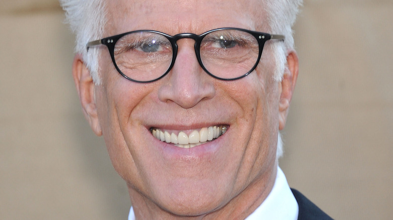 Ted Danson smiles in black-frame glasses.