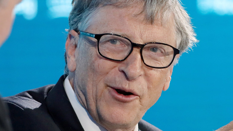 Bill Gates speaking and looking to his right side in a pair of glasses
