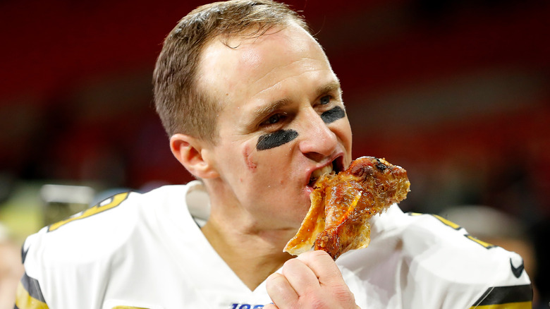 Drew Brees eating a turkey leg in Saints gear