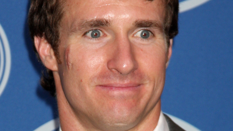 Drew Brees poses in a suit and tie 