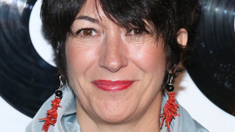 Ghislaine Maxwell tight lipped smile, red earrings