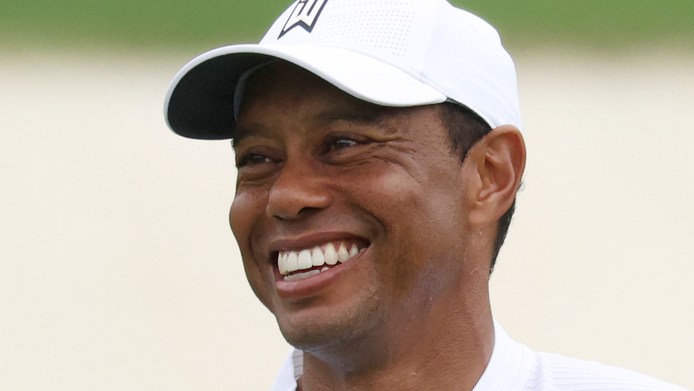 Tiger Woods smiles on a golf course in 2020