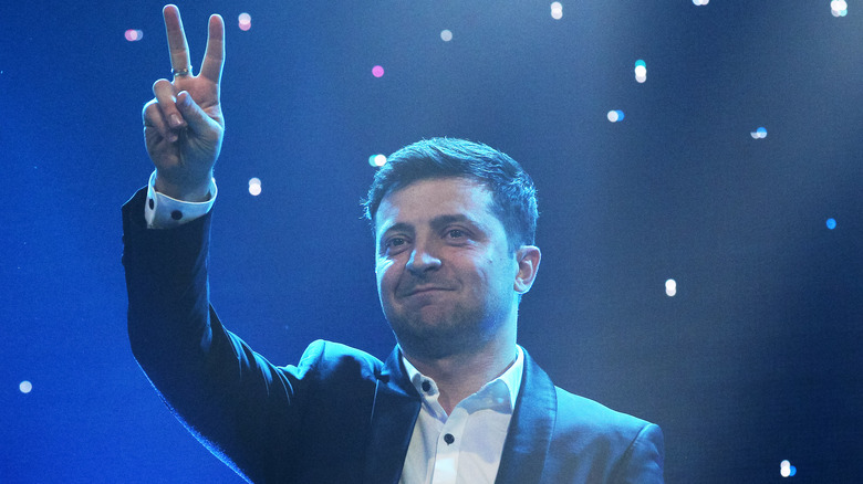 Volodymyr Zelenskyy giving peace sign on stage
