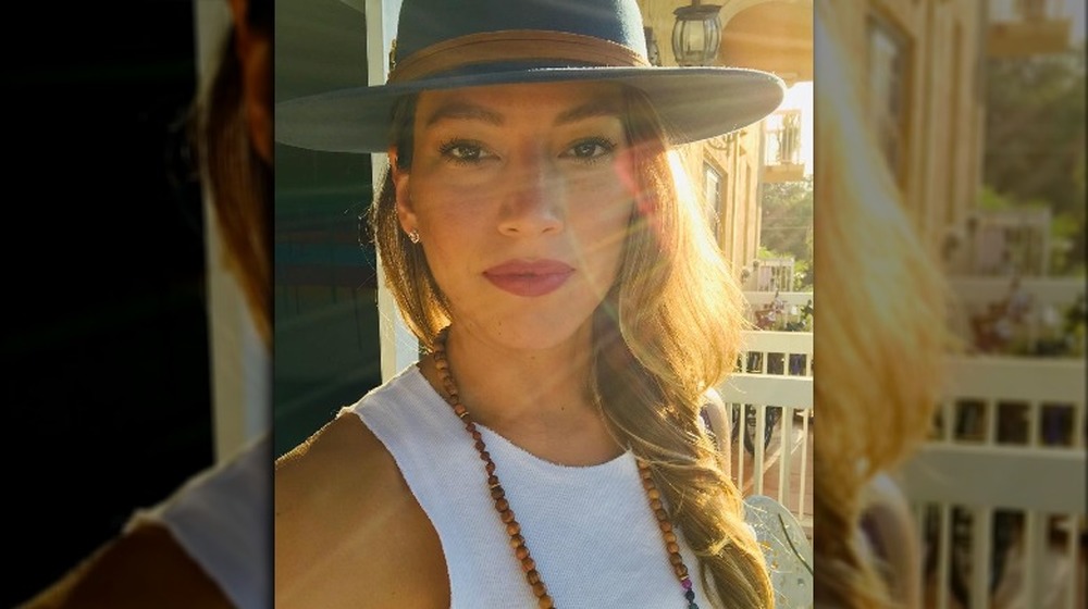 Diana Lasso wears a blue rimmed hat with her hair down near her shoulders in a selfie