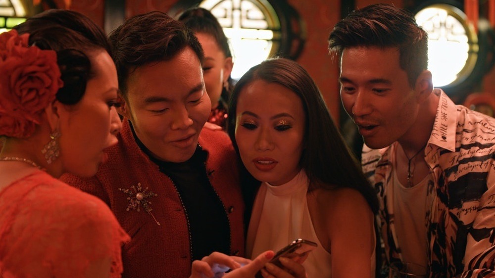 Members of the 'Bling Empire' cast staring a phone