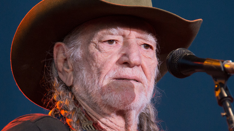 Willie Nelson on stage wearing a hat.