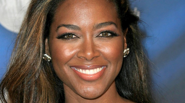 Kenya Moore smiles with messy hair