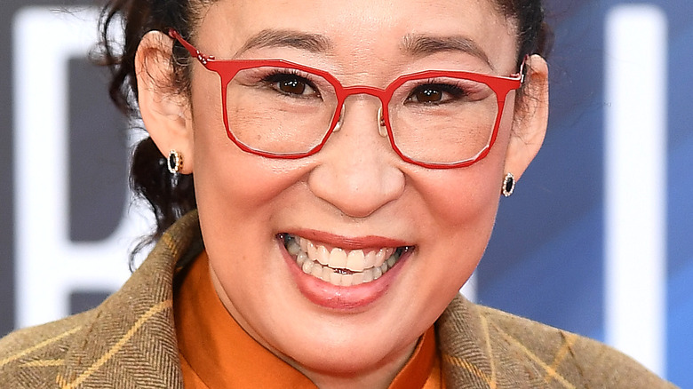 Sandrah Oh wearing red-rimmed glasses