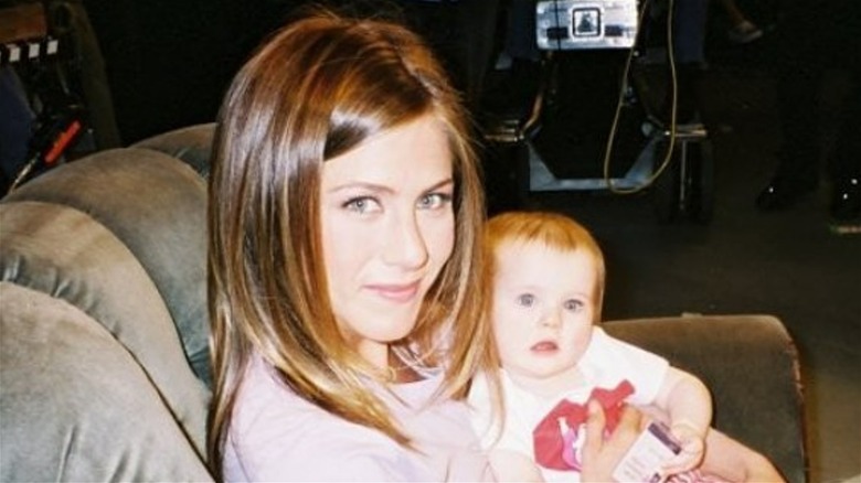 Jennifer Anniston smiling and holding baby Cali Sheldon