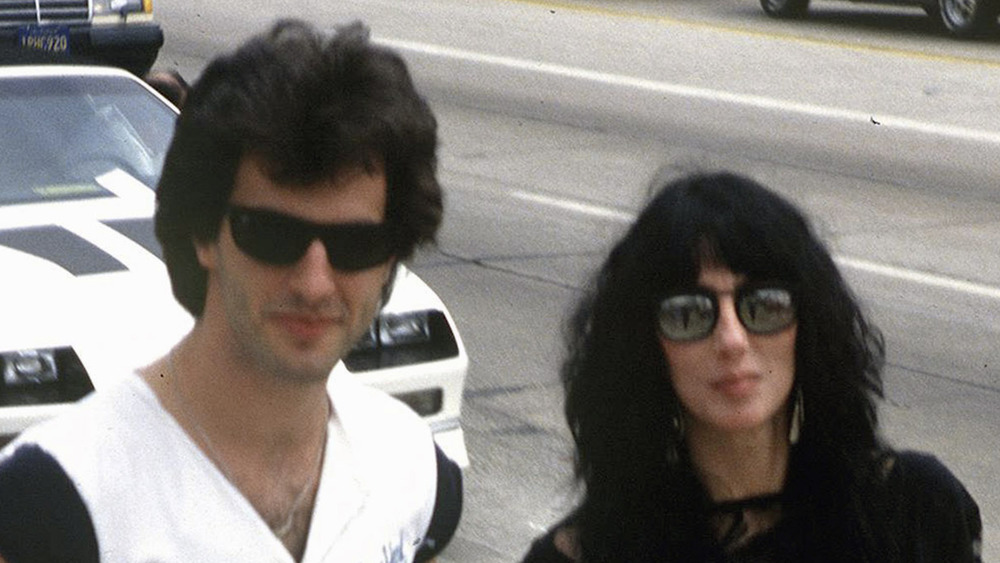 Robert Camilletti and Cher in front of a car