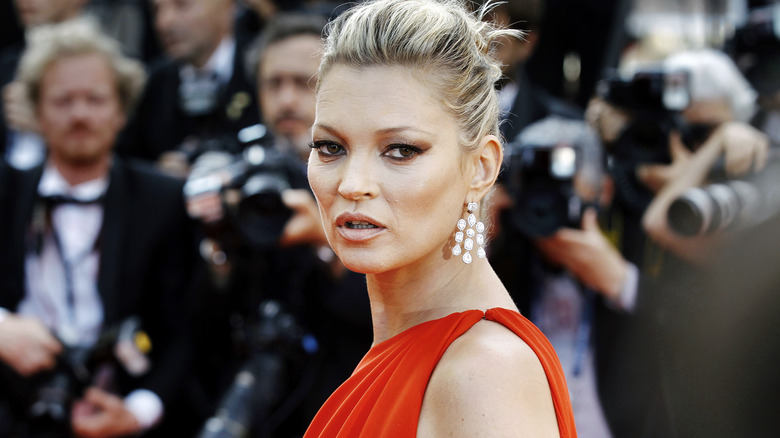 Kate Moss posing in a red dress