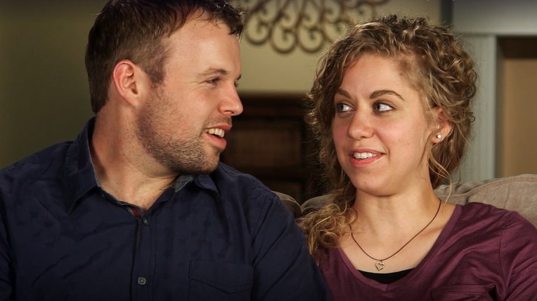 John David and Abbie Duggar sitting on a couch