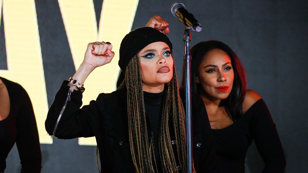 Andra Day with her fist up during a performance