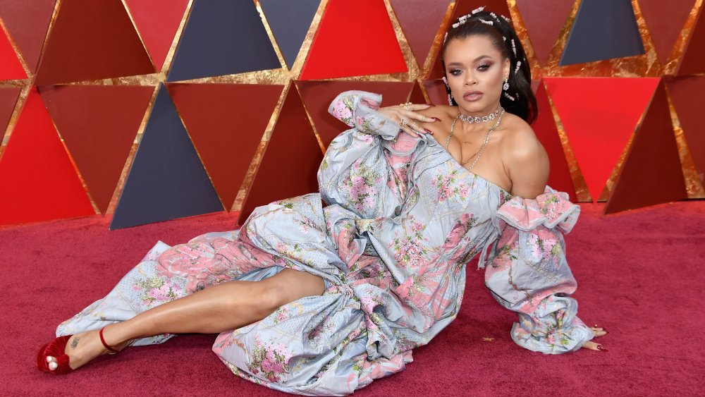 Andra Day striking a pose while sitting down on the red carpet
