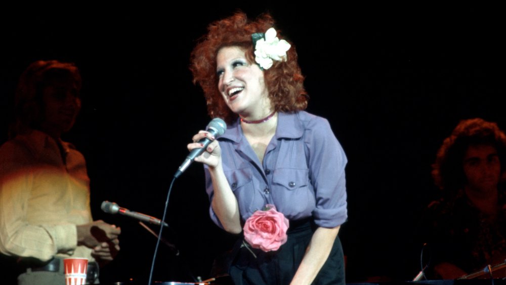 Bette Midler singing with a flower in her hair