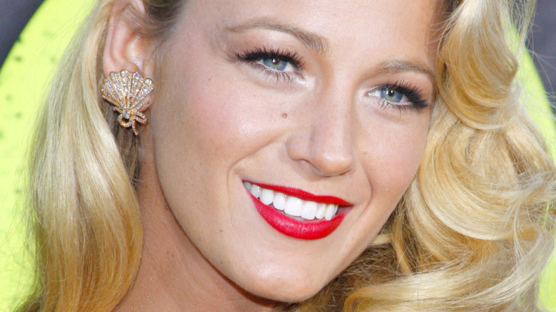 Blake Lively on the red carpet, smiling with red lips