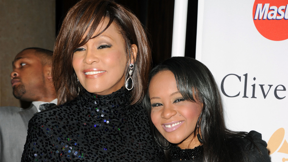 Bobbi Kristina Brown and mom Whitney Houston smiling on the red carpet