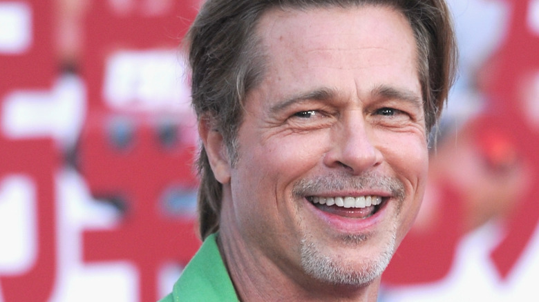 Brad Pitt in a green suit, smiling