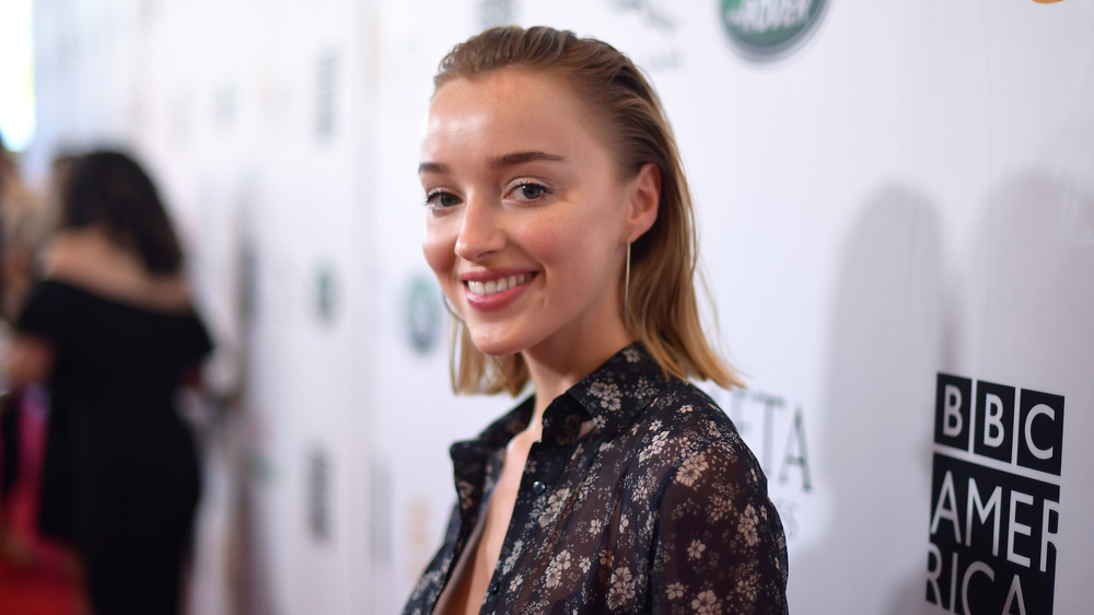 Phoebe Dynevor smiling on a red carpet