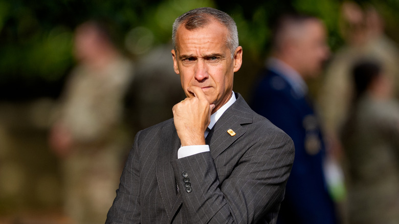 Corey Lewandowski thinking in a courtyard in 2025.