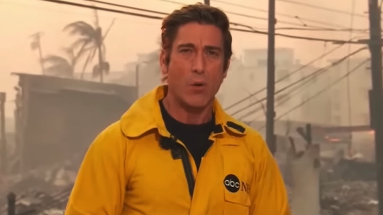David Muir reporting outdoors in a yellow jacket