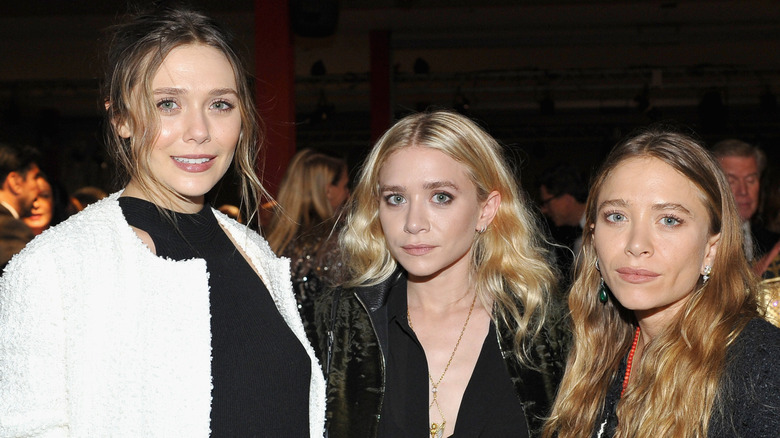 Elizabeth Olsen, Ashley Olsen, and Mary-Kate Olsen posing together