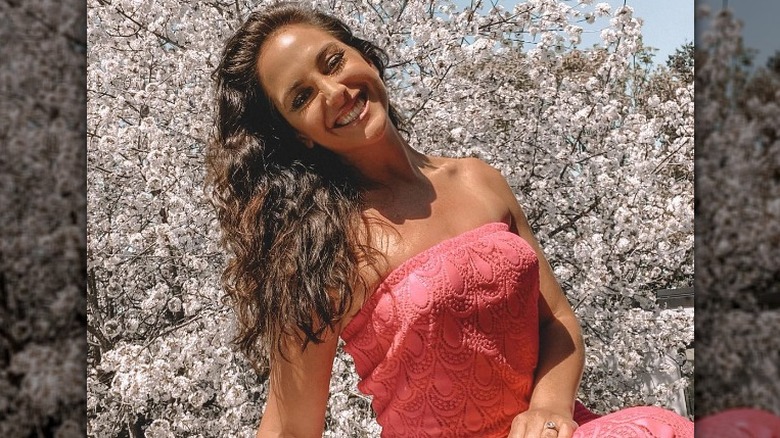 Emily Compagno posing for cameras in front of cherry blossoms
