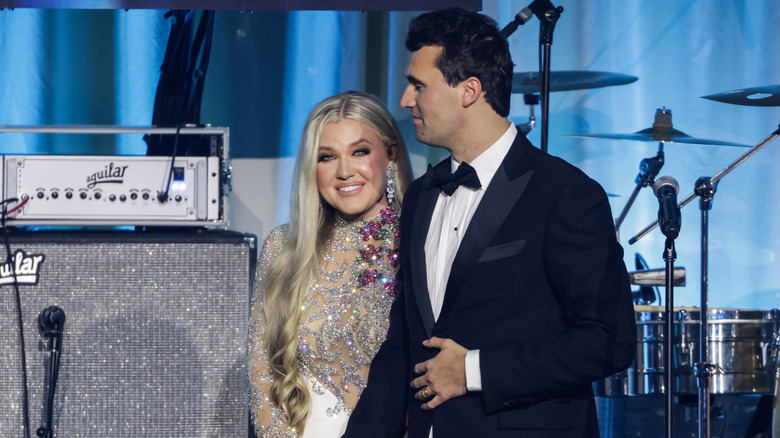 Charlie Kirk and Erika Kirk walking on stage at a black tie event