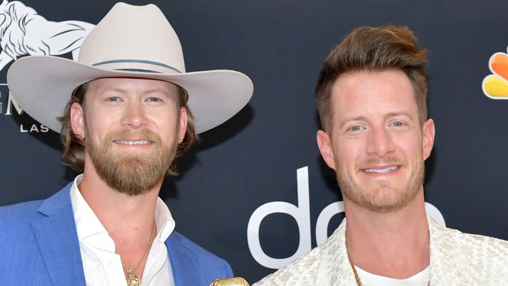 Brian Kelley with a cowbow hat on next to Tyler Hubbard