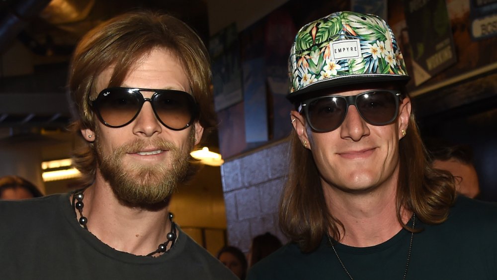 Tyler Hubbard with sunglasses on next to Brian Kelley, also with sunglasses