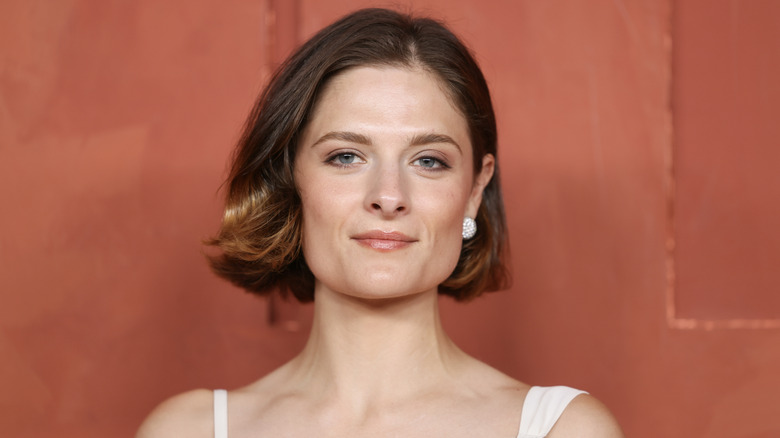 Louisa Jacobson posing in front of a orange-hued background