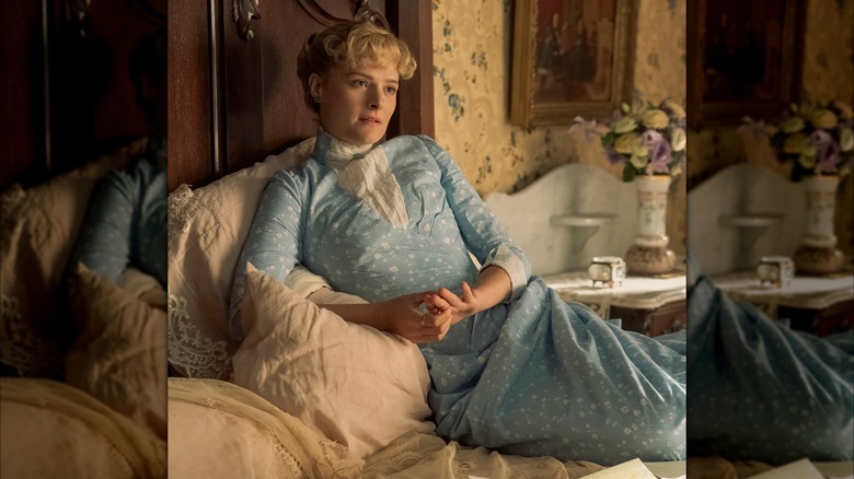 Louisa Jacobson lying in bed in a scene from The Gilded Age