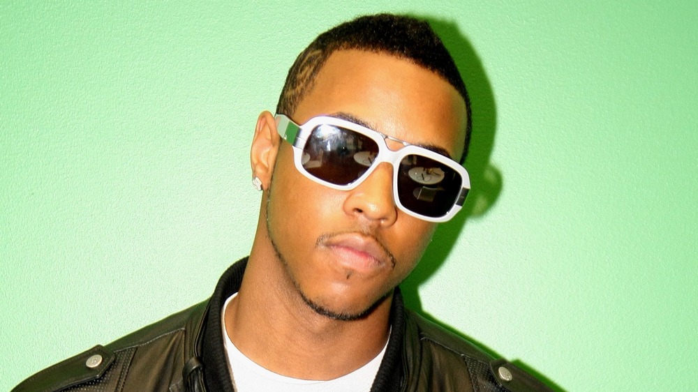 Jeremih in white-framed sunglasses, posing in front of a green screen