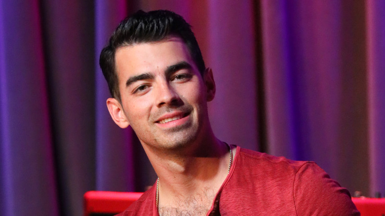 Joe Jonas sitting in a chair 