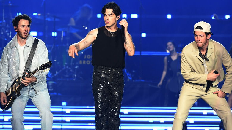 Nick, Kevin, and Joe Jonas on stage performing