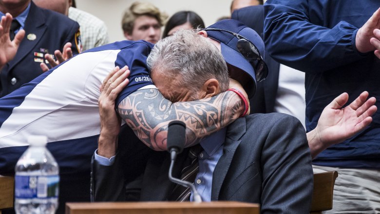 Jon Stewart receives a hug from FealGood Foundation founder John Feal
