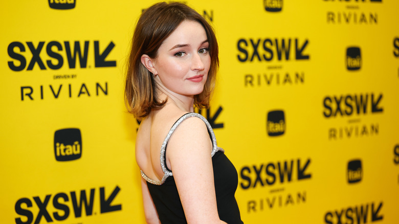 Kaitlyn Dever posing in front of a yellow background at SXSW