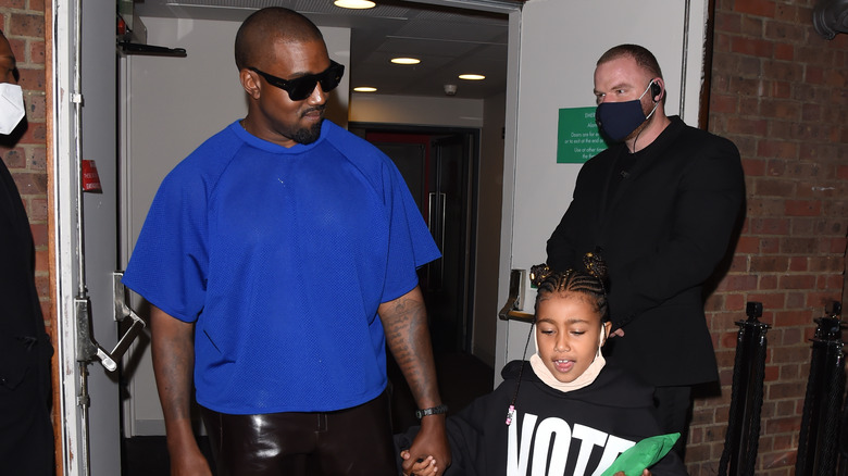 Kanye West holding his daughter North West's hand