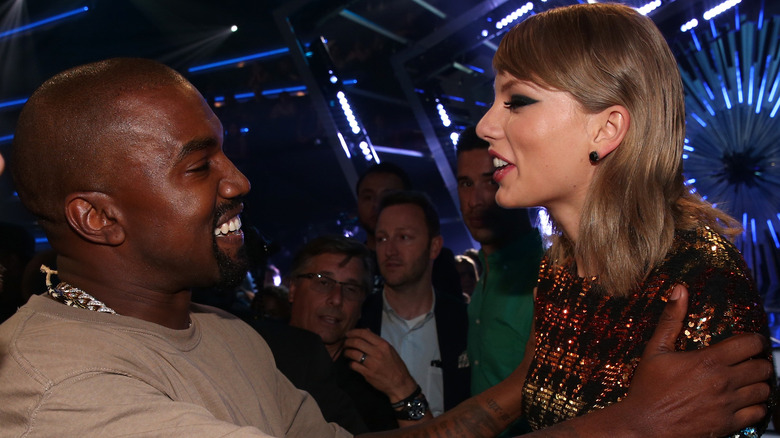 Kanye West and Taylor Swift smiling at each other