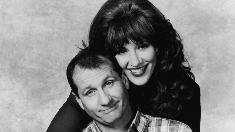 Ed O'Neill and Katey Sagal as Peggy and Al Bundy, posing for a portrait
