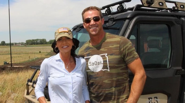 Kristi and Bryon Noem smiling in front of truck